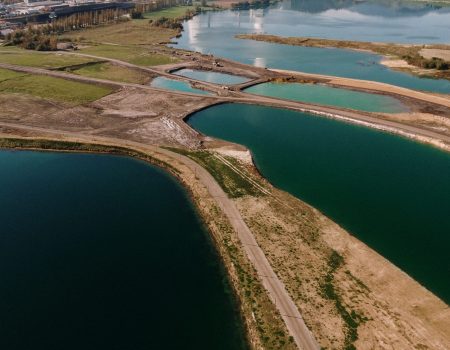 An aerial shot of a landscape surrounded by mountains and lakes with industrial disaster